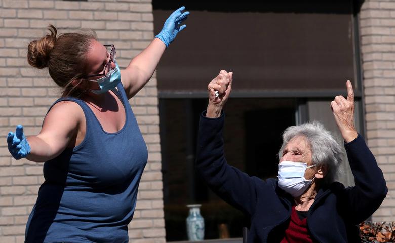 Một nhân viên chăm sóc tại viện dưỡng lão ở Boortmeerbeek, Bỉ nhảy múa bên cạnh một cụ bà