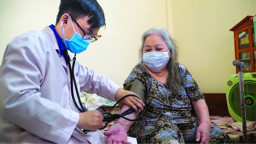 Nhân viên y tế của Bệnh viện Thống Nhất đang chăm sóc sức khỏe tại nhà cho một bệnh nhân