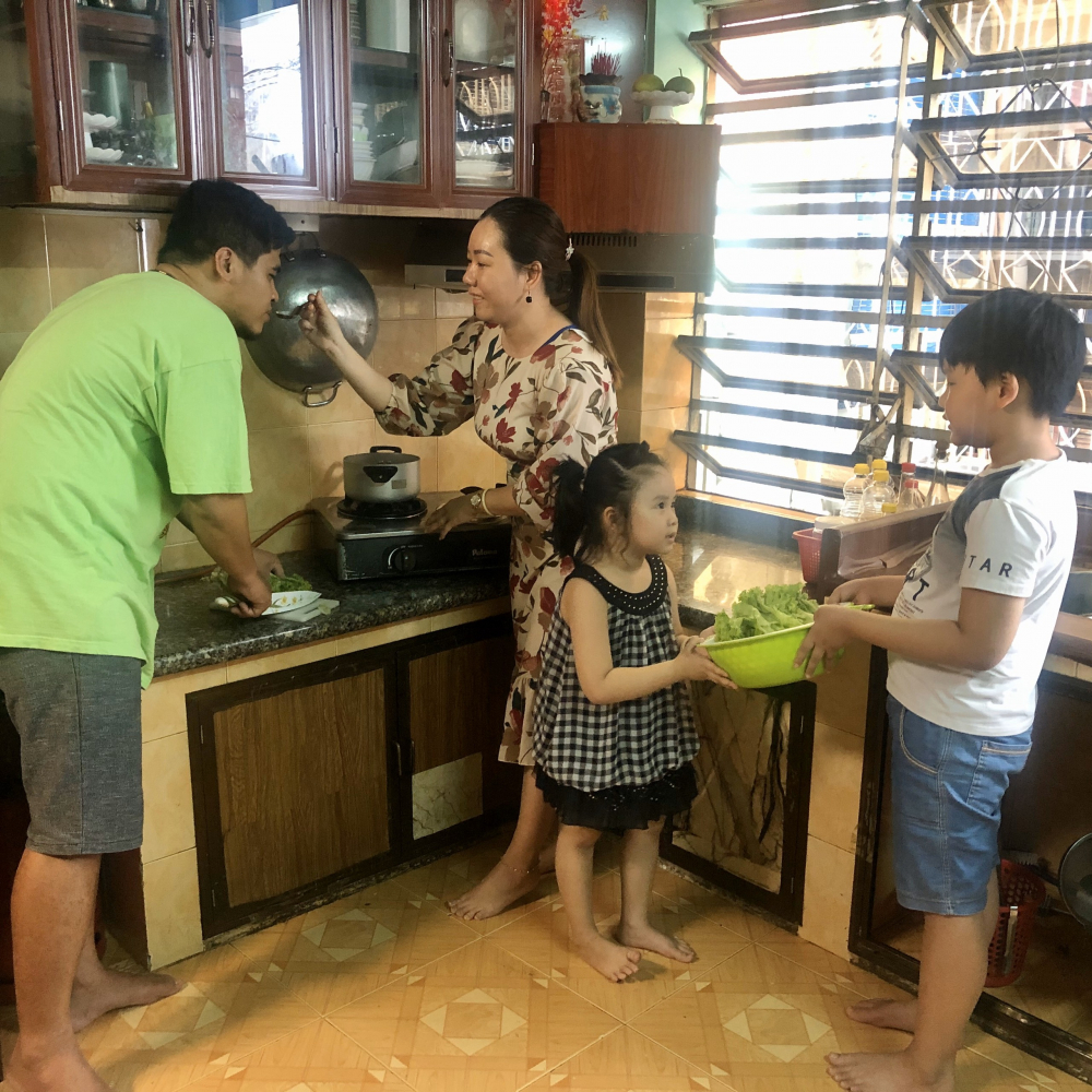 Một gia đình quây quần nấu ăn ngày giãn cách xã hội. Ảnh minh hoạ