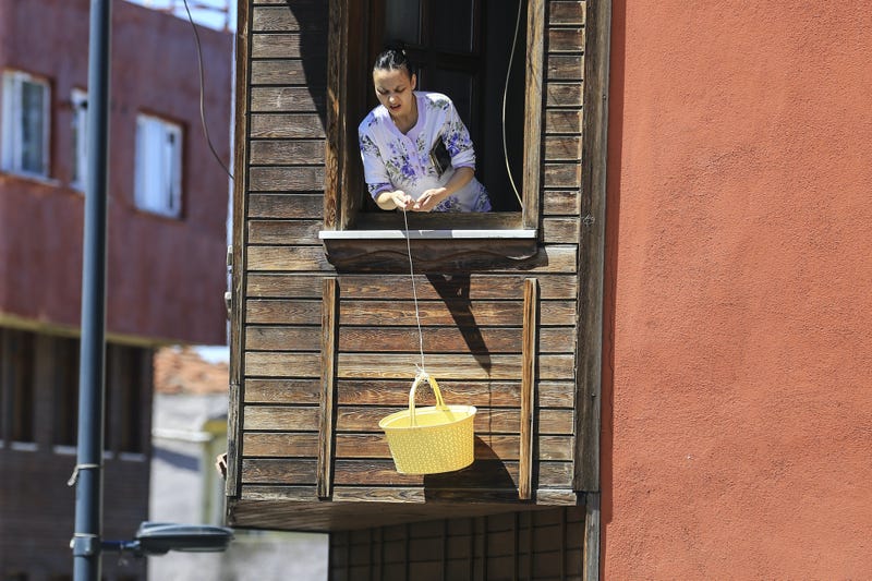 Một người phụ nữ gửi một giỏ trên một chuỗi sử dụng nó như một thang máy từ cửa sổ bay của mình để mua bánh mì từ tiệm bánh di động trong thời gian hạn chế vào nửa đêm tại 31 tỉnh trong hai ngày tại Istanbul, Thổ Nhĩ Kỳ vào ngày 18 tháng 4 năm 2020.