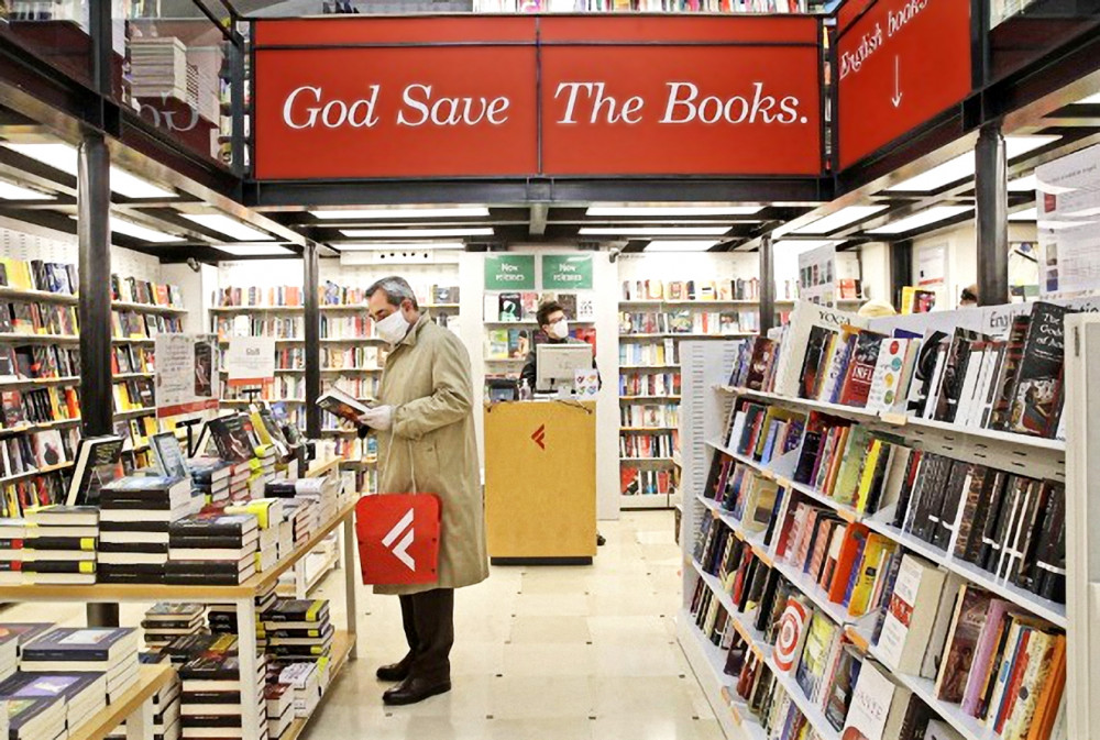 Một người đàn ông chọn mua sách tại cửa hàng ở Rome, Ý ngày 20/4 - Ảnh: AP