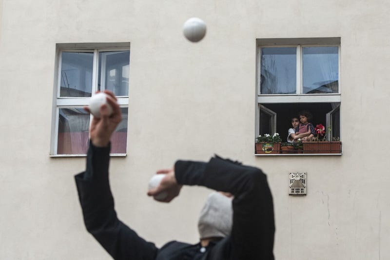 Ở Prague, trẻ em nhìn ra ngoài cửa sổ để xem những người tung hứng và các thành viên khác của một công ty xiếc đương đại biểu diễn trên sân thượng.