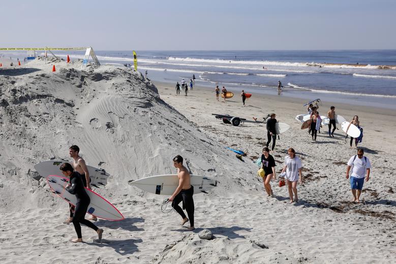 Một nhóm người rời bãi biễn Encinitas, California sau khi lướt ván, tắm biển.