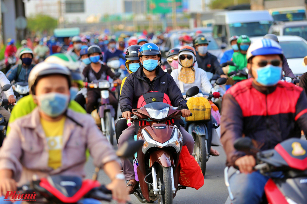 Từ khoảng 17h15, lượng phương tiện đổ về quốc lộ 1A đoạn qua huyện Bình Chánh rất đông khiến dòng xe máy chen chúc, nối đôi nhau xếp hàng dài.
