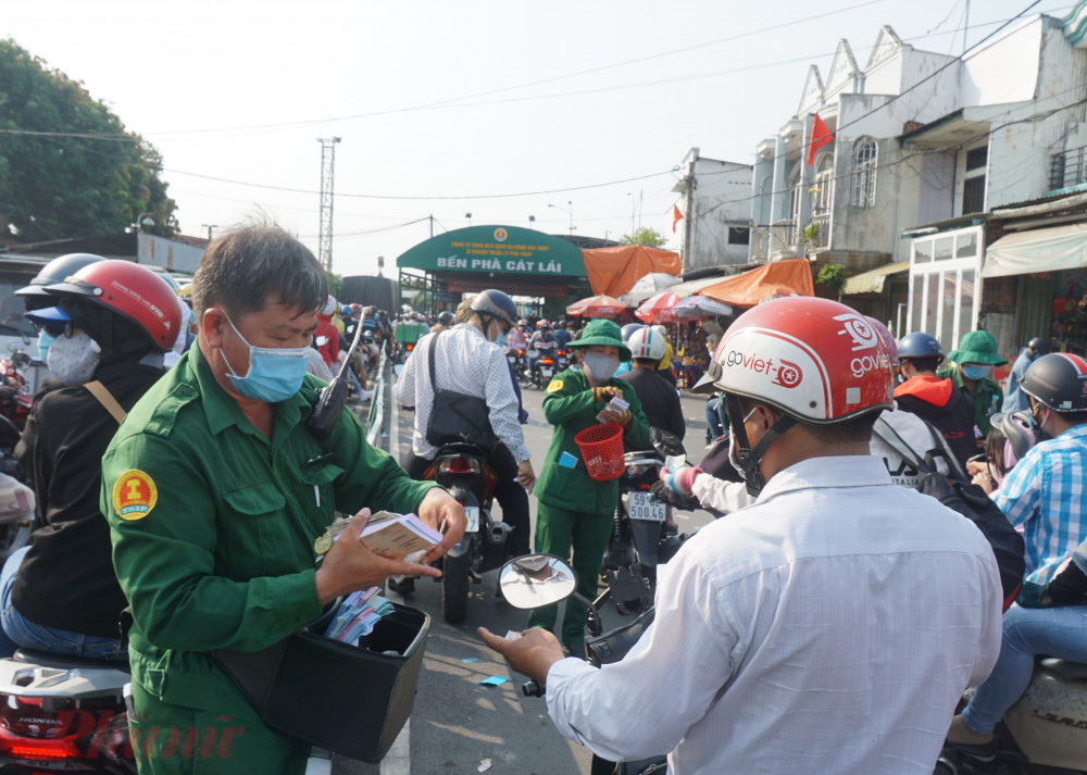 Để giải tỏa lượng xe đổ về quá lớn, nhân viên tại phà Cát Lái phải đi bộ để phát vé thủ công