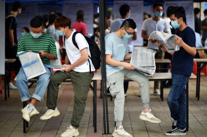 Người tìm việc đọc quảng cáo tại một hội chợ việc làm ở Hải Khẩu, đảo Hải Nam. (Ảnh: Tân Hoa Xã)