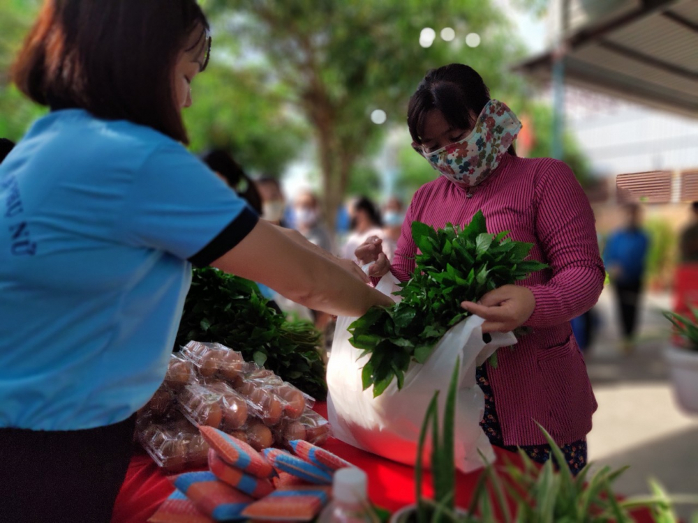 Chị em nhận rau nhà trồng, các loại thực phẩm khô và sản phẩm dùng trong nhà bếp do cán bộ Hội phường Thới An tự tay làm. 