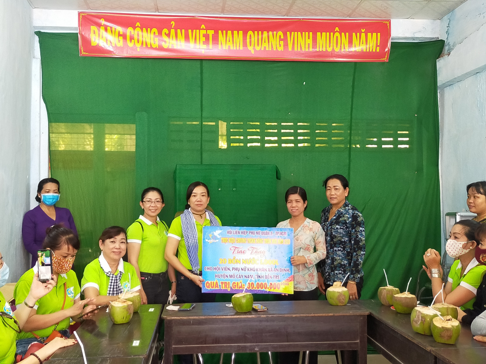 Bà Nguyễn Thị Tuyết Nga (thứ 2, từ trái qua) - Chủ tịch Hội LHPN quận 2 - trao bảng tượng trưng các gói hỗ trợ 