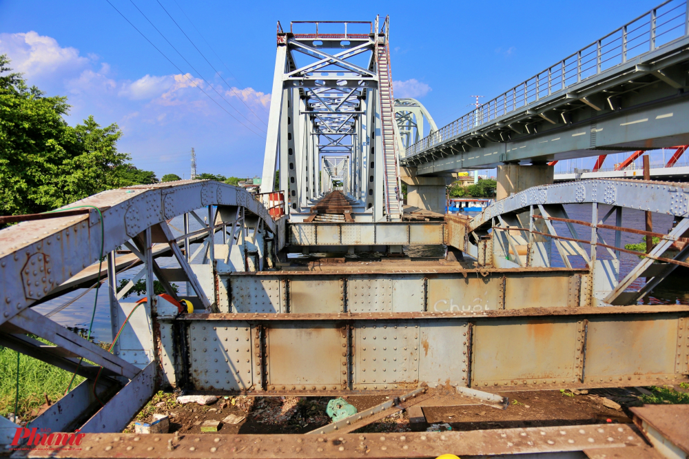  Cầu sắt Bình Lợi cũ 118 tuổi nối quận Thủ Đức - quận Bình Thạnh (TPHCM) có tĩnh không thấp, 1,8m, gây cản trở giao thông nên được các công nhân đang được tháo dỡ để tạo điều kiện thành phố phát triển giao thông đường thủy.