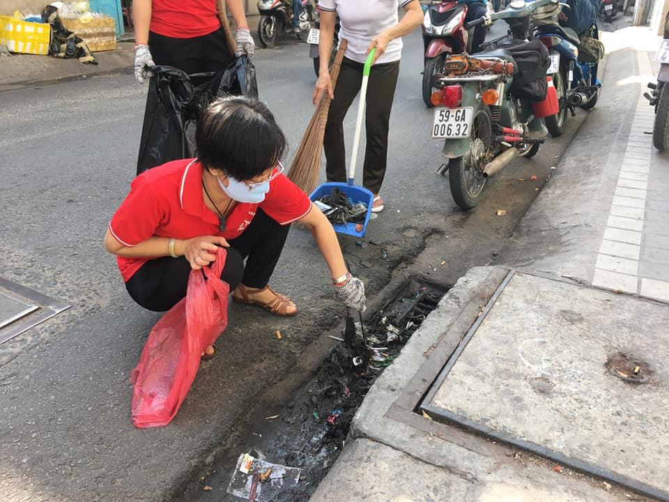 Các dì, chị ra quân làm sạch đường phố, gắp rác tại  các miệng cống thoát nước. 