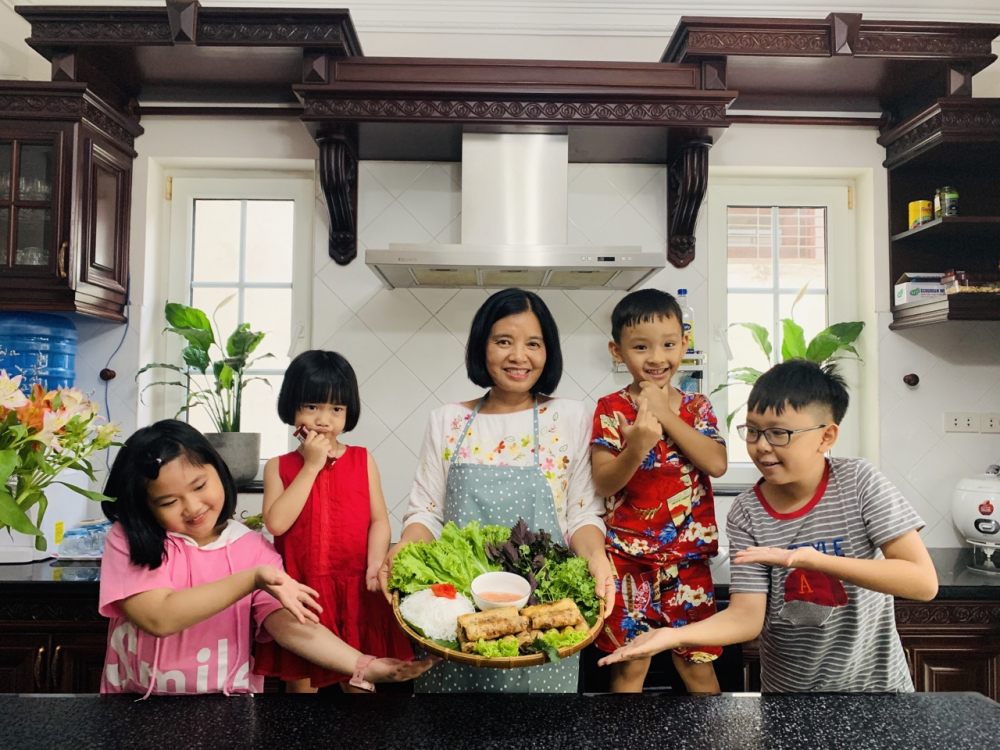 Chị Phạm Thị Lợi cùng con cháu trong gian bếp gia đình thực hiện món nem rán. 