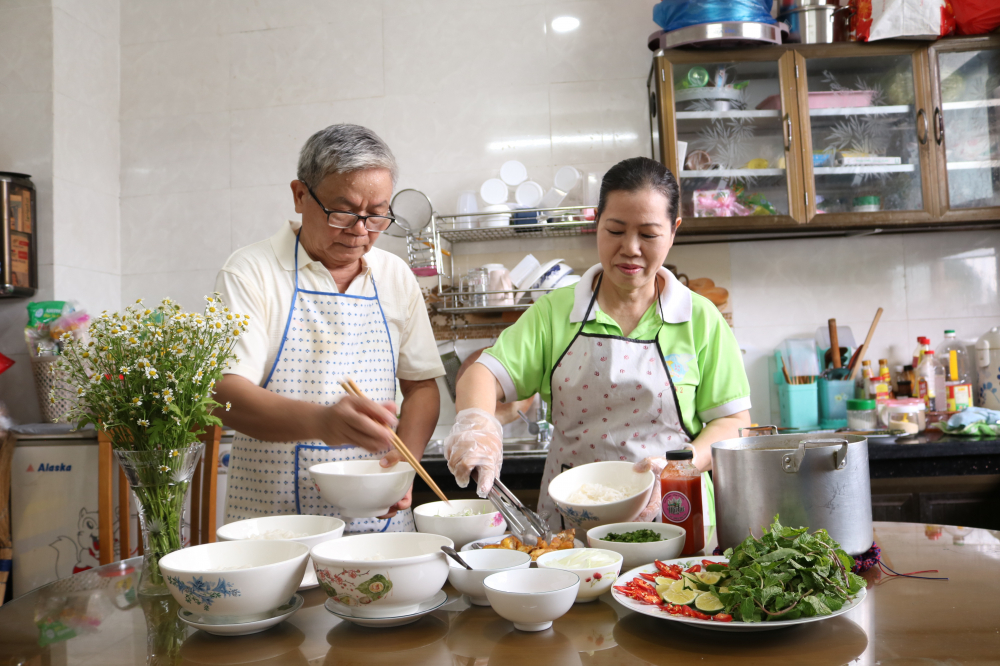 Vợ chồng bà Nguyễn Thị Chi cùng nấu món canh cá Quỳnh Côi. 