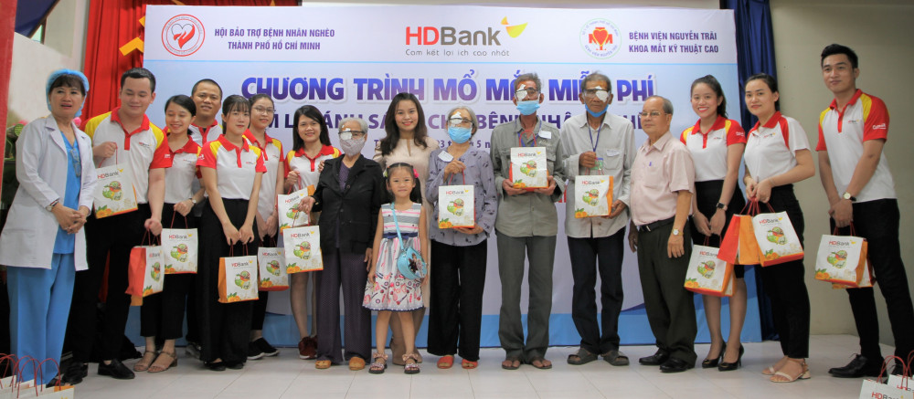 Bà Trần Thu Hương - Phó giám đốc phụ trách Khối vận hành HDBank (áo trắng đứng giữa) và cán bộ, nhân viên HDBank trao quà cho bà con. Ảnh: HDBank cung cấp