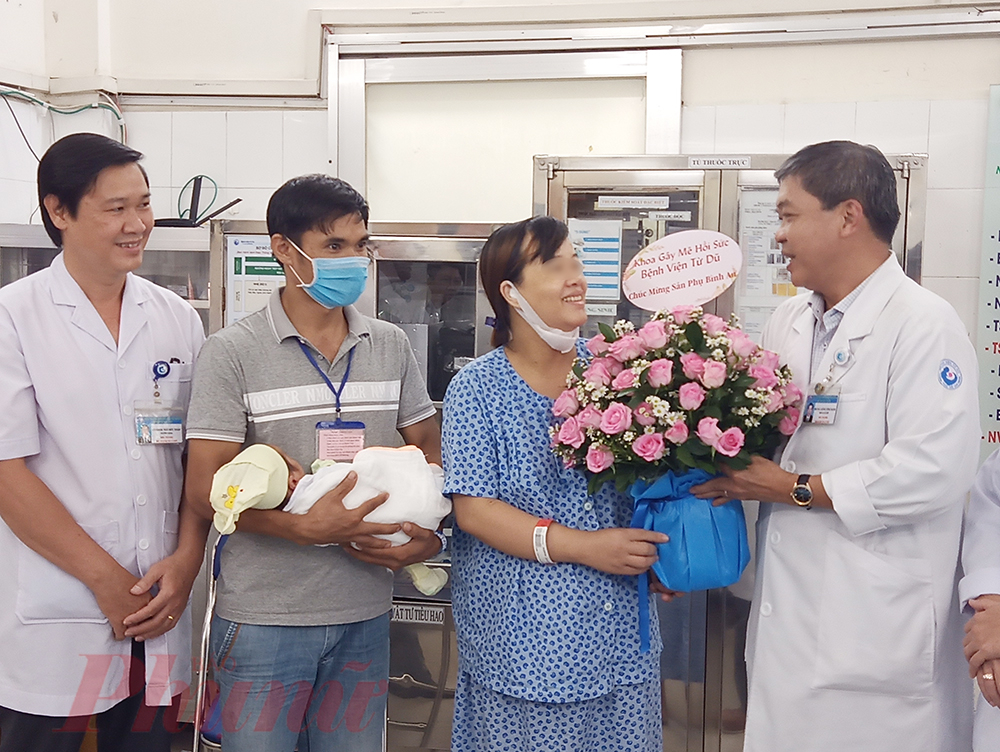 Bác sĩ CKII Hồng Công Danh - Phó Giám đốc Bệnh viện Từ Dũ tặng hoa chúc mừng gia đình chị T. đã bình an bên nhau