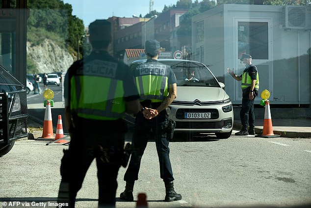 Các sĩ quan cảnh sát Tây Ban Nha tại trạm kiểm soát gần La Jonquera kiểm tra một chiếc xe hơi vượt qua biên giới Pháp-Tây Ban Nha.