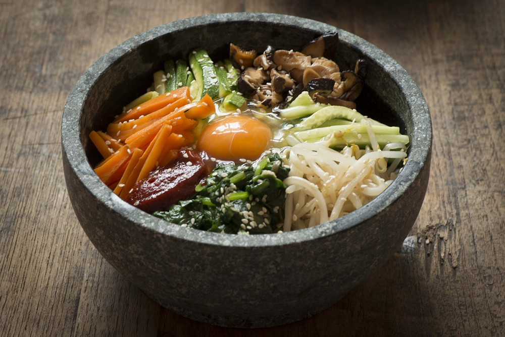 Bibimbap dịch là cơm trộn với thịt và rau là một món ăn truyền thống của Hàn Quốc. Nó được làm với thịt bò sống và lòng đỏ trứng sống. Gạo trắng được ăn kèm với kim chi, hành tây, trứng, nấm... Bibimbap đặc biệt hơn khi dùng với nước sốt gochujang sẽ mang lại hương vị đậm đà.