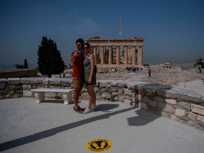 Một cặp đôi khách du lịch chụp ảnh tại thành cổ  the Acropolis (Athens)