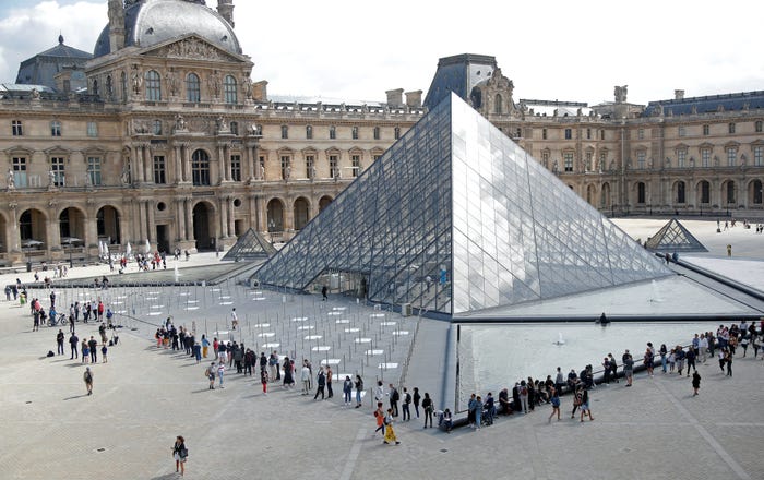 Du khách xếp hàng để vào Kim tự tháp ở bảo tàng Louvre 