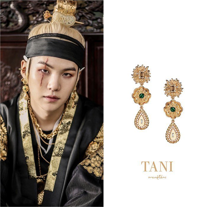 BTS Suga đầy mạnh mẽ trong sắc phục đen, vàng truyền thống của triều đại Joseon. Vòng cổ và khuyên tai vàng giúp nam thần tượng có vẻ ngoài nổi bật.