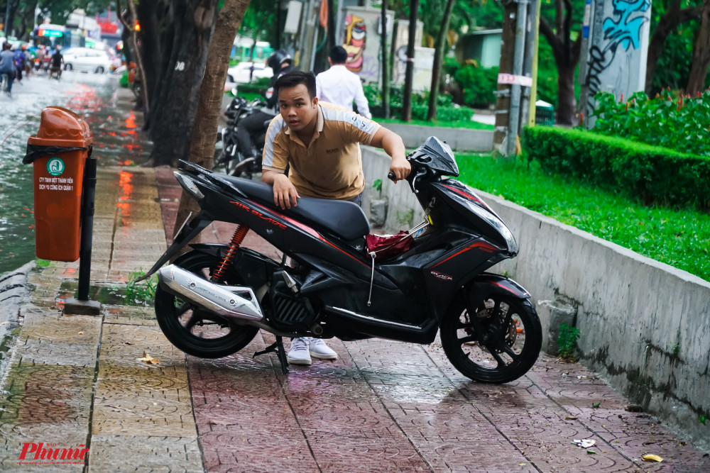 Các phương tiện chết máy, đậu trên vỉa hè chờ nước rút