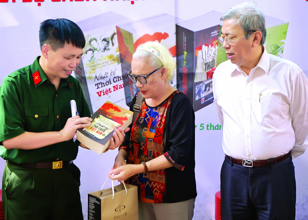 Trao tặng bộ sách cho đại diện gia đình liệt sĩ Chu Cẩm Phong - ảnh: nhân vật cung cấp