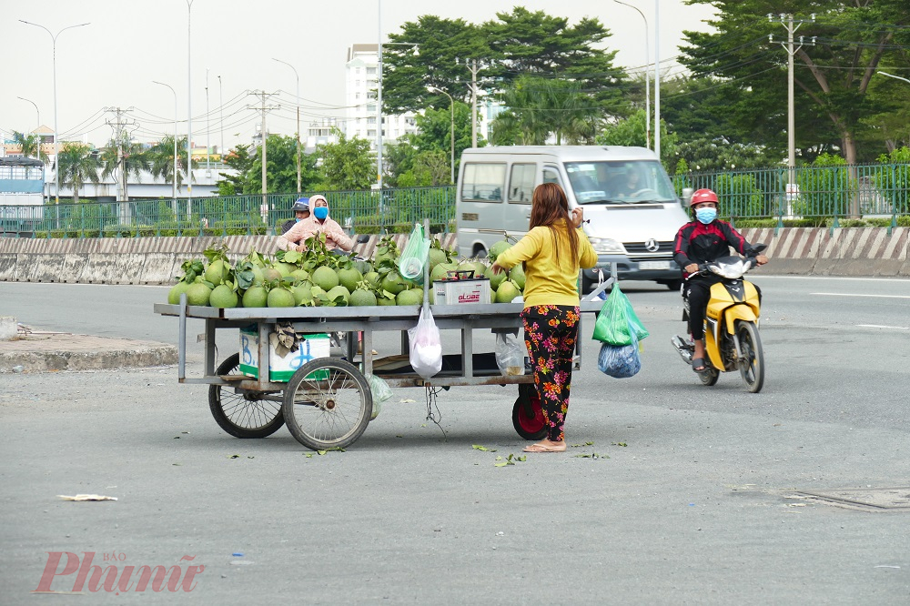 3. Bất chấp nguy hiểm, một người phụ nữ kéo xe bưởi ra giữa ngã tư để chào mời khách mua. Ghi nhận của phóng viên, dù các tuyến đường này thường xuyên bị tắc nghẽn nhưng không hề có lực lượng Cảnh sát giao thông làm nhiệm vụ trên đường.