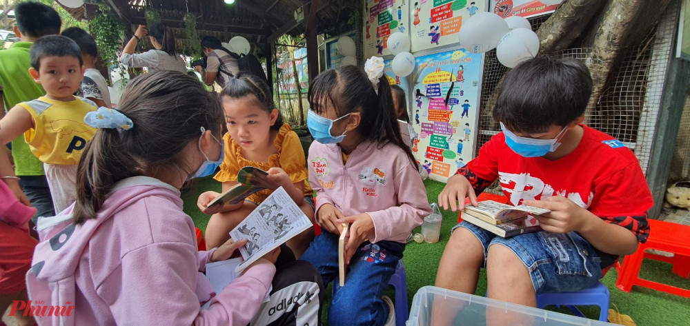 Trẻ nhỏ thích thú ngồi đọc sách, truyện tranh 