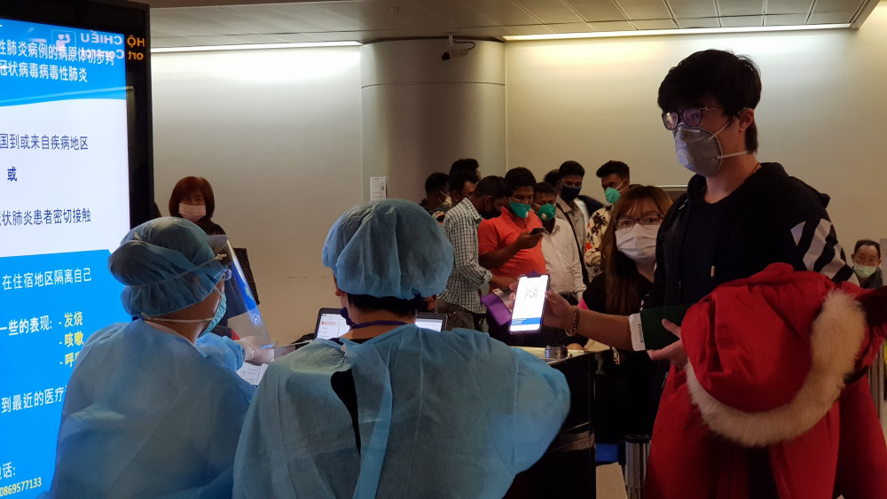 Nhân viên y tế hướng dẫn người đến khai báo y tế tại sân bay.