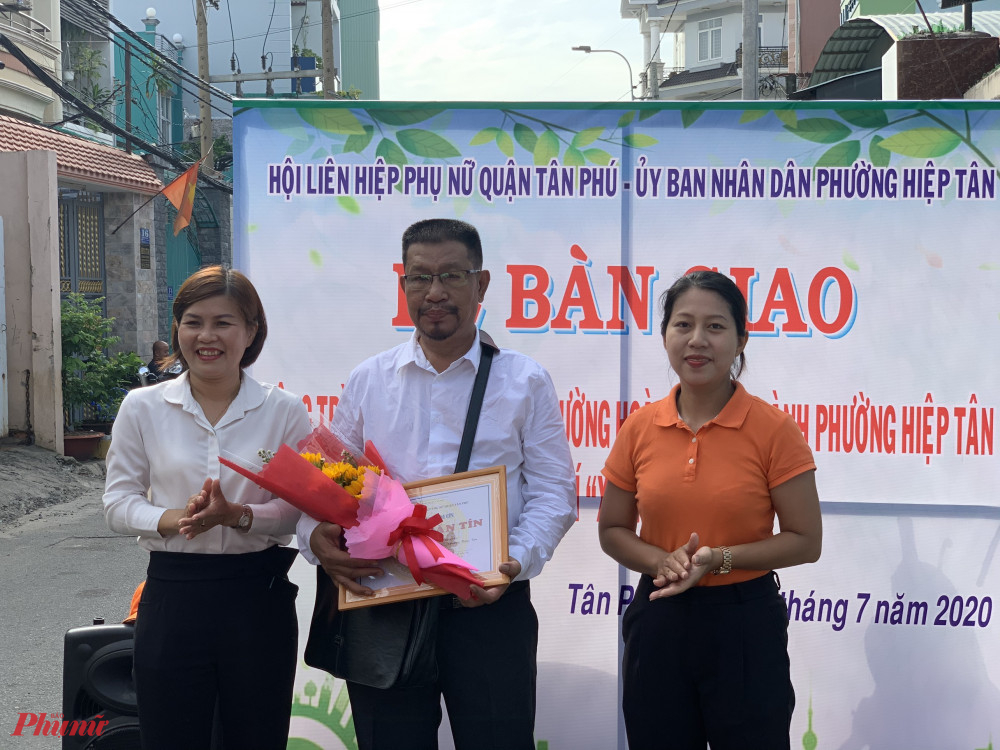 Hội LHPN quận Tân Phú tặng hoa, cám ơn sự góp sức từ họa sĩ vẽ các bức tranh tuyên truyền cổ động