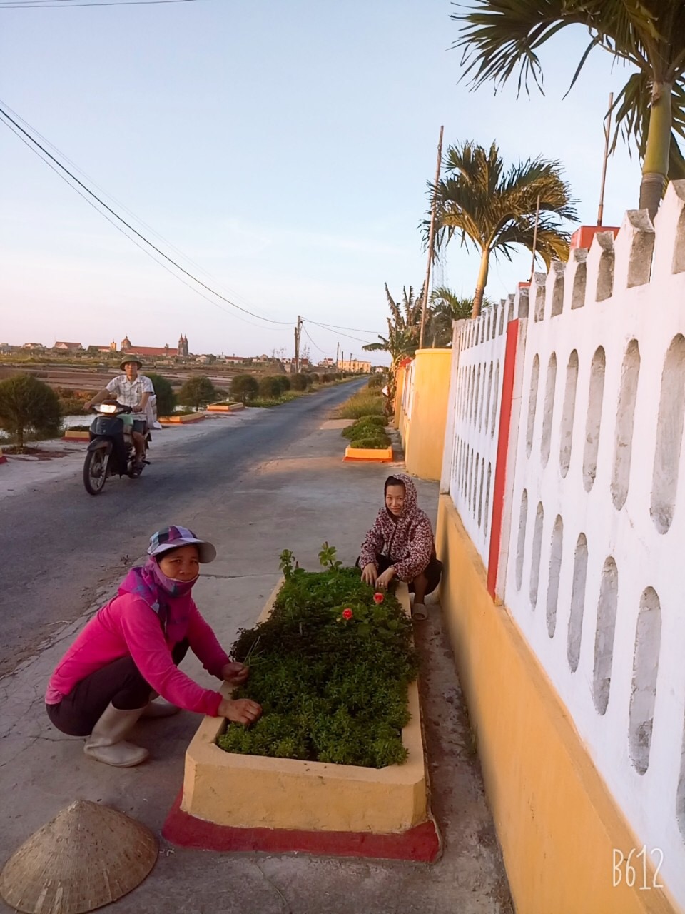 Chị Nguyễn Thị Tằm (bên trái) chăm sóc hoa kiểng trên tuyến đường của Xóm Trung Chính.