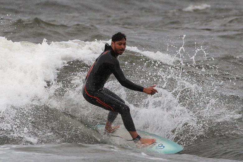 Bất chấp nguy hiểm, một người đàn ông vẫn chơi lướt ván trên biển khi bão đổ bộ vào khu vực Rockaway của thành phố New York hôm 4/8