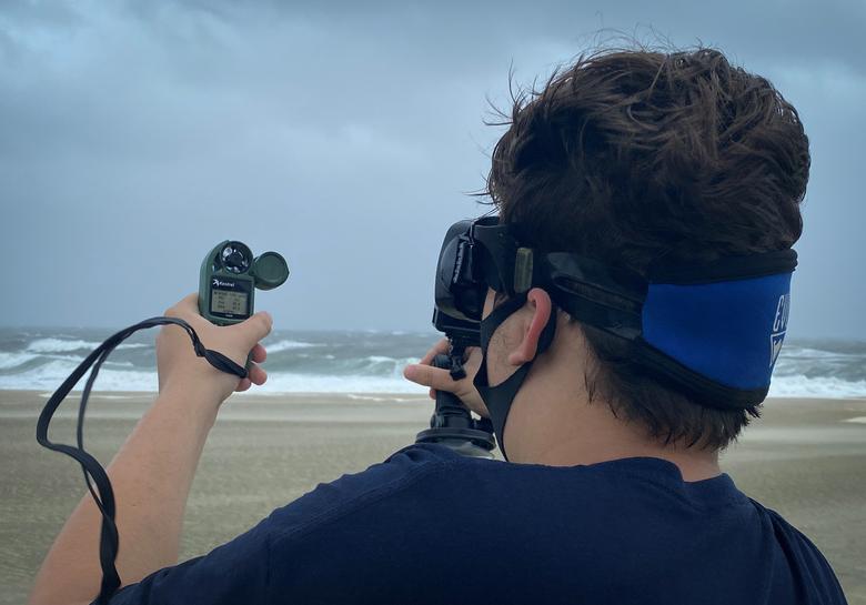 Kylie Lizzq đo tốc độ gió khi anh đứng trên một bãi biển trong cơn bão nhiệt đới Isaias ở Sea Girt, New Jersey