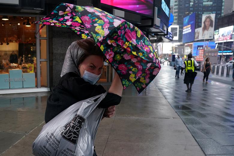Một người phụ nữ vật lộn với chiếc dù trong cơn gió lớn tại Quảng trường Thời Đại.
