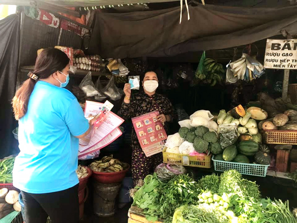 Tiểu thương ở H.Bình Chánh nhận tờ rơi và khẩu trang 