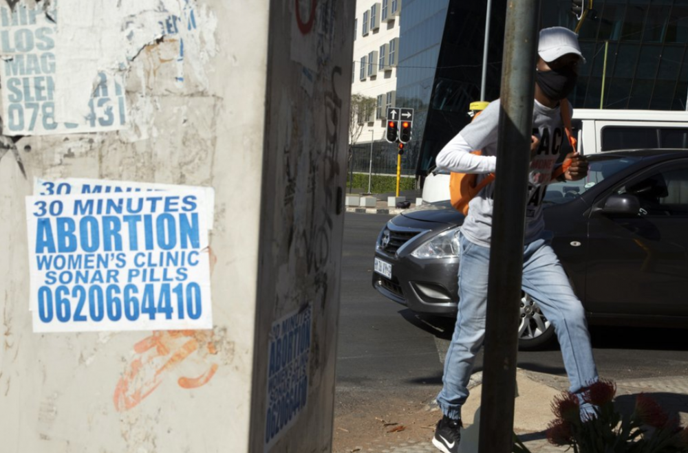 Hình ảnh các áp-phích phòng khám phá thai được dán khắp con phố Johannesburg, Nam Phi - Ảnh: AP