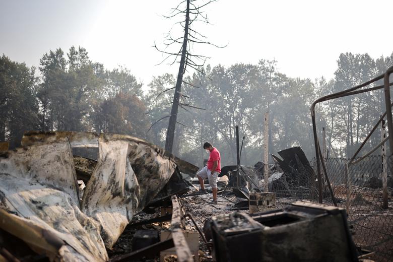 Một người đàn ông bên đống đổ nát do cháy rừng tàn phá ở Phoenix, Oregon 