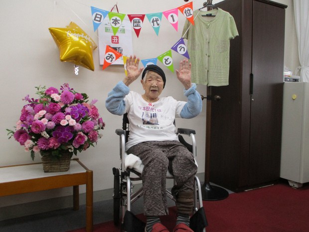 Bà Tanaka bận chiếc áo do gia đình gửi tặng và tự ăn mừng bằng một chai Coke.
