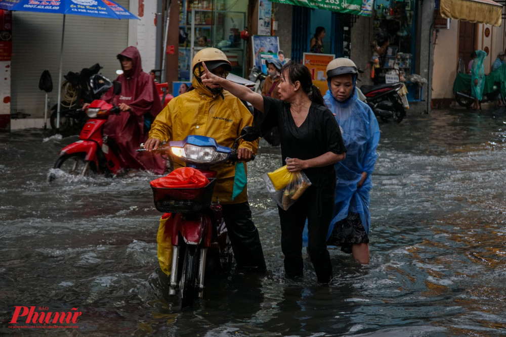 Người dân chỉ hướng đi khác tránh ngập cho người lưu thông