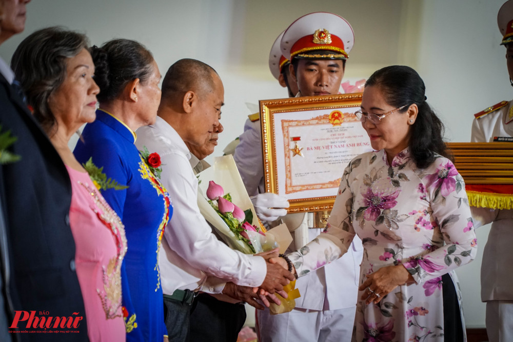 Bà Nguyễn Thị Lệ - Chủ tịch HĐND TPHCM bắt tay chúc mừng đại diện các gia đình được truy tặng dnah hiệu