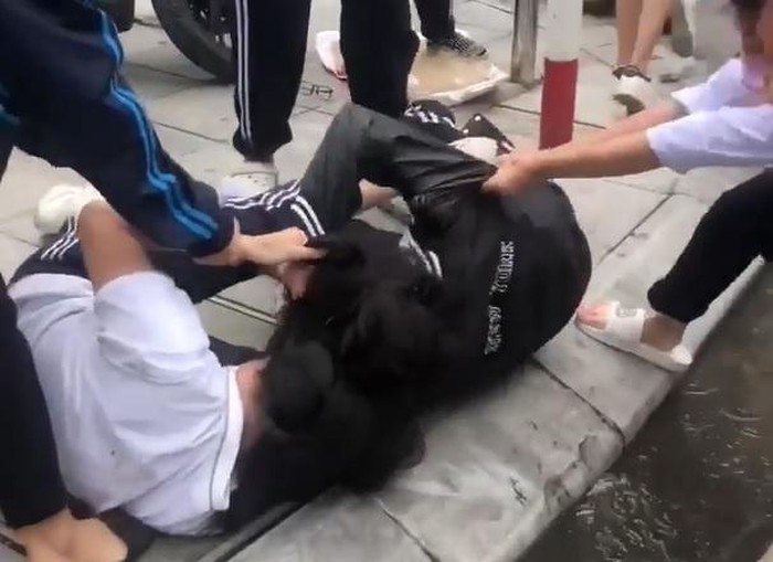 Hình ảnh nữ sinh lớp 10 ở Hà Nội đánh nhau trước cổng trường (ảnh cắt từ clip)