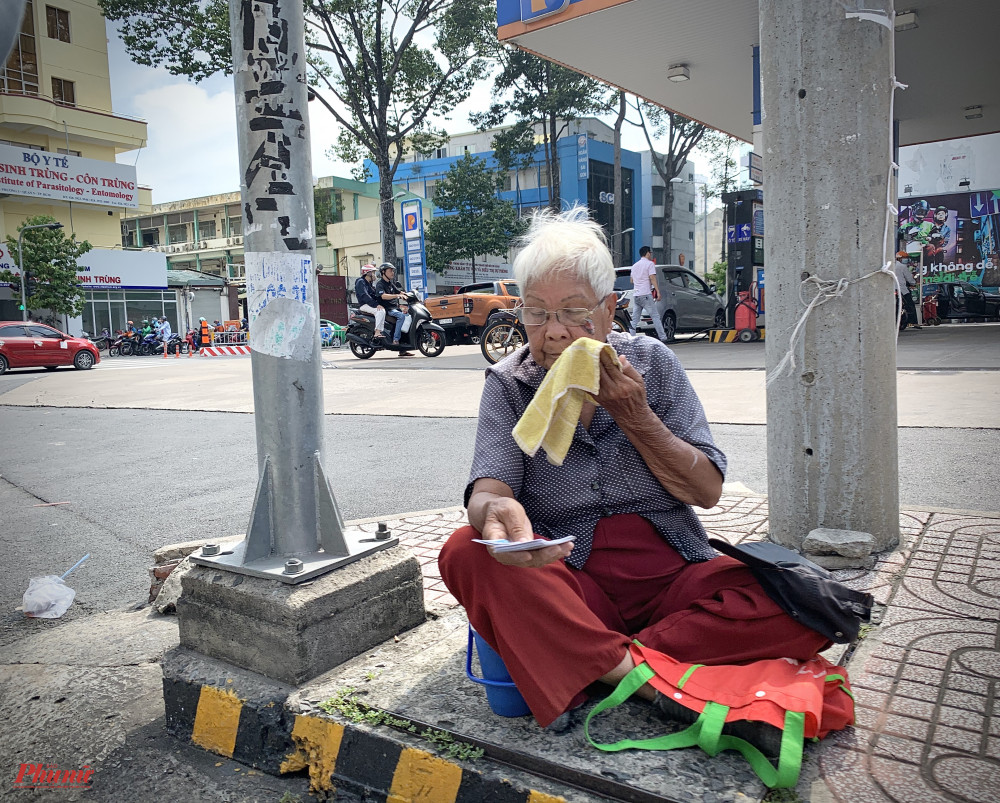 Không nhiều người có sự lựa chọn như ông Nhị, họ buộc phải mưu sinh để tự lo cho chính mình vì cạnh bên không còn người thân thích. Bà Tân, 85 tuổi, quê ở Trà Vinh đằm mình giữa cái nắng 2 giờ chiều ngay góc ngã tư Nguyễn Biểu - Trần Hưng Đạo, quận 5. Bà không còn người thân, bản thân lại mang bệnh nên phải mưu sinh để kiếm tiền lo thuốc thang, ăn uống hằng ngày. 