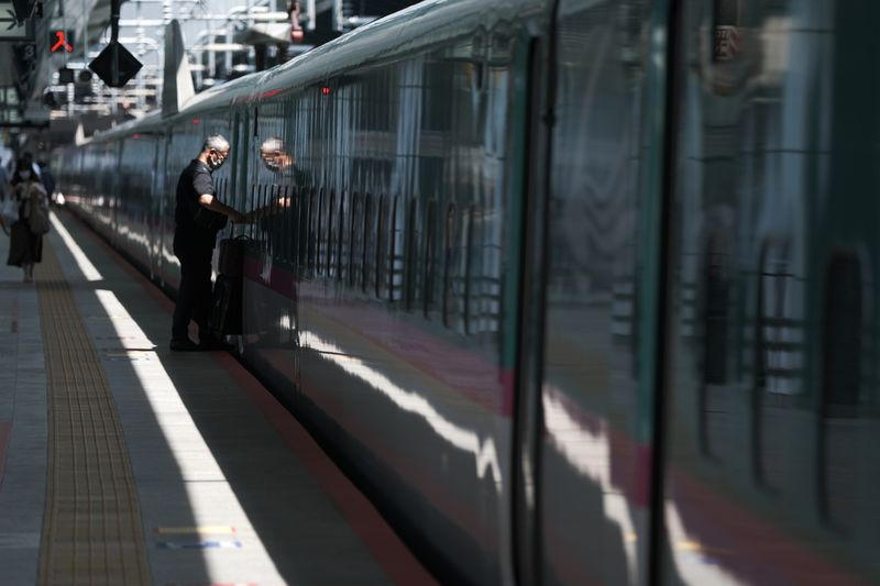 Một hành khách lên tàu cao tốc Shinkansen của công ty EJR tại Ga đường sắt Tokyo - Ảnh: Bloomberg