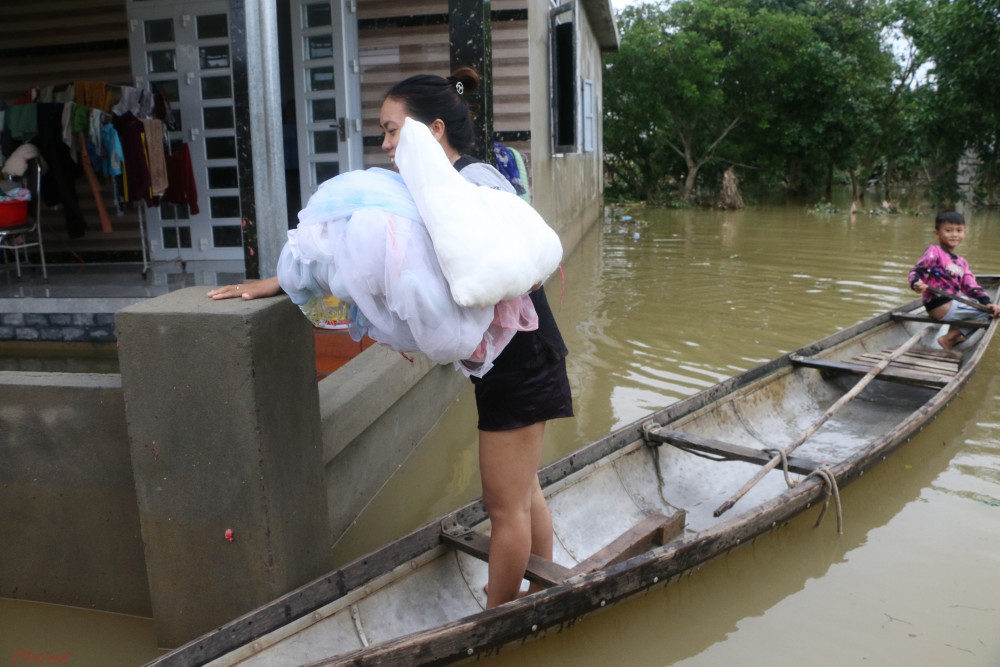 Người dân vùng lũ bơi xuồng đi nhận quà cứu trợ của các Mạnh Thường Quân.