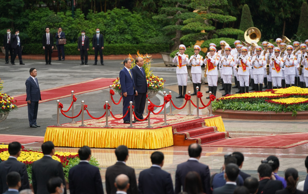 Thủ tướng Nguyễn Xuân Phúc và Thủ tướng Nhật Bản Suga Yoshihide trên bục danh dự, nghe quân nhạc cử Quốc thiều hai nước. 