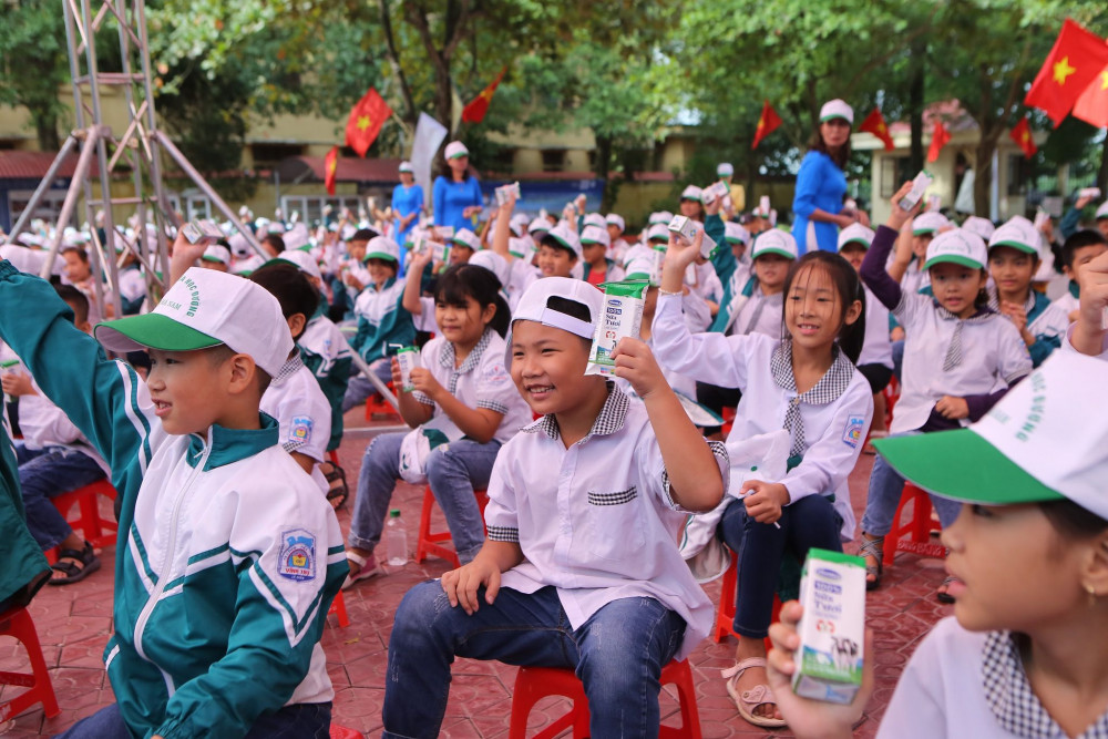 Các em học sinh Trường tiểu học A hào hứng tham gia hoạt động uống sữa cùng các bạn tại sân trường trong buổi lễ phát động. Ảnh: Vinamilk