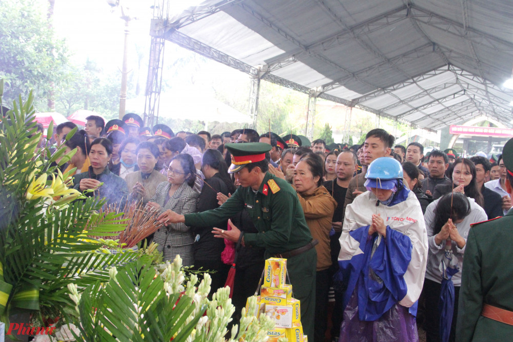 Nhiều người đứng giữa mưa chờ đợi vào thắp hương vĩnh biệt người con của quê hương