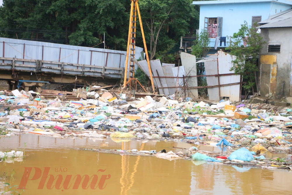 Bà Lê Thị Mông một hộ dân sinh sống gần cầu Vân Dương cho biết, nguyên nhân rác tồn ứng mắc kẹt sau lũ là do nhà thầu thi cầu Vân Dương quá chậm, thậm chị trước lũ không tập kết các phương tiện cơ giới phục vụ thi công cầu  khiến dòng nên rác  tồn động, 