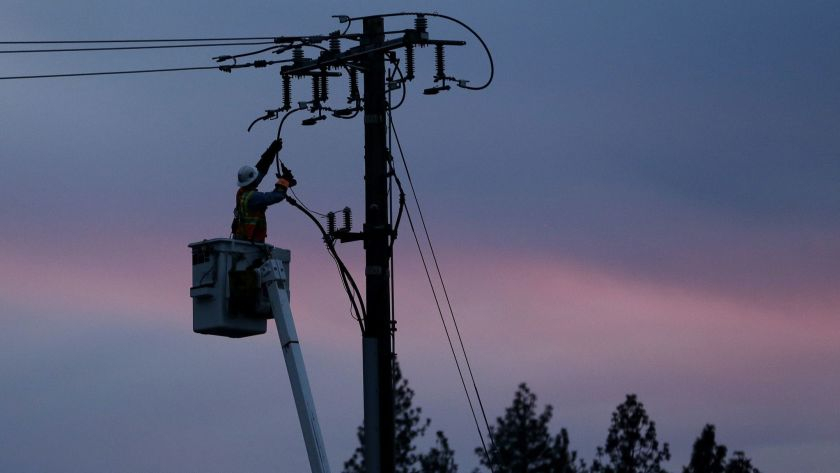 Công nhân điện lực PG&E khôi phục dòng điện sau khi cơn bão quét qua Paradise, California - Ảnh: AP