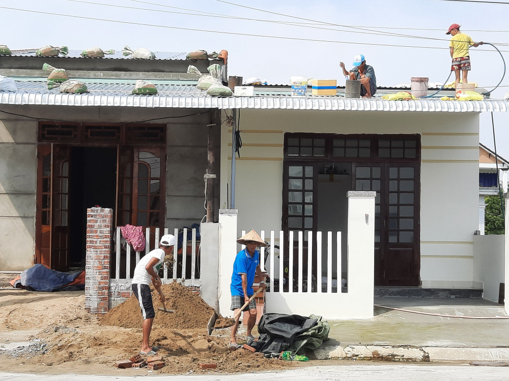 Người dân Quảng Nam đang đưa những bao cát lên mái tôn đề chèn, chống bão