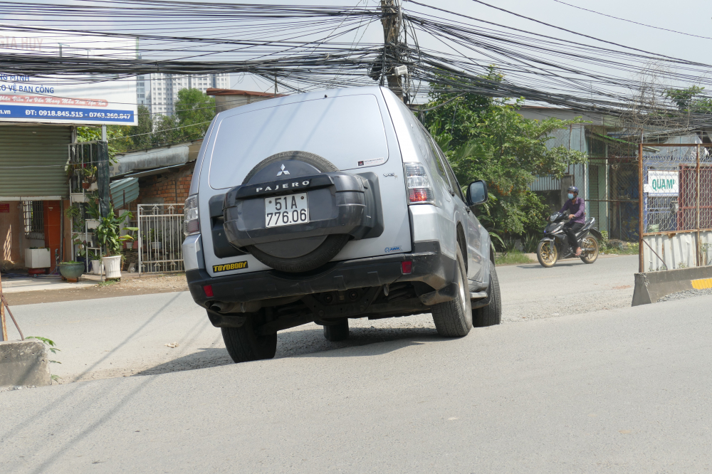 Một chiếc xe hơi di chuyển với tốc độ chậm khi lưu thông trên đoạn đường đau khổ